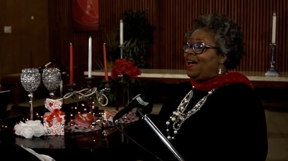 A woman is singing into a microphone in a church