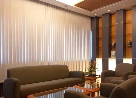Waiting room with grey seating, beige blinds, and wooden accents.