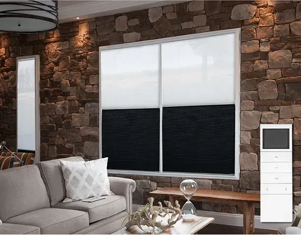 Living room with stone wall, light gray sofa, and black and white window shades.