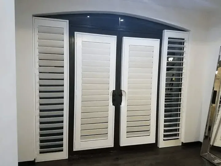 White interior doors with shutters and a dark frame.