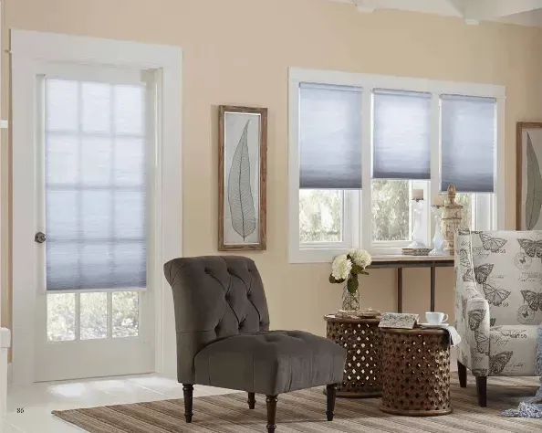 Living room with light peach walls, light blue honeycomb shades, and gray upholstered furniture.