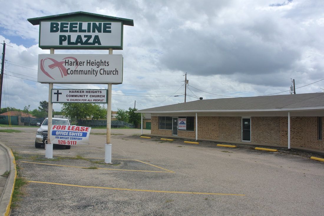 A sign for beeline plaza is above a parking lot