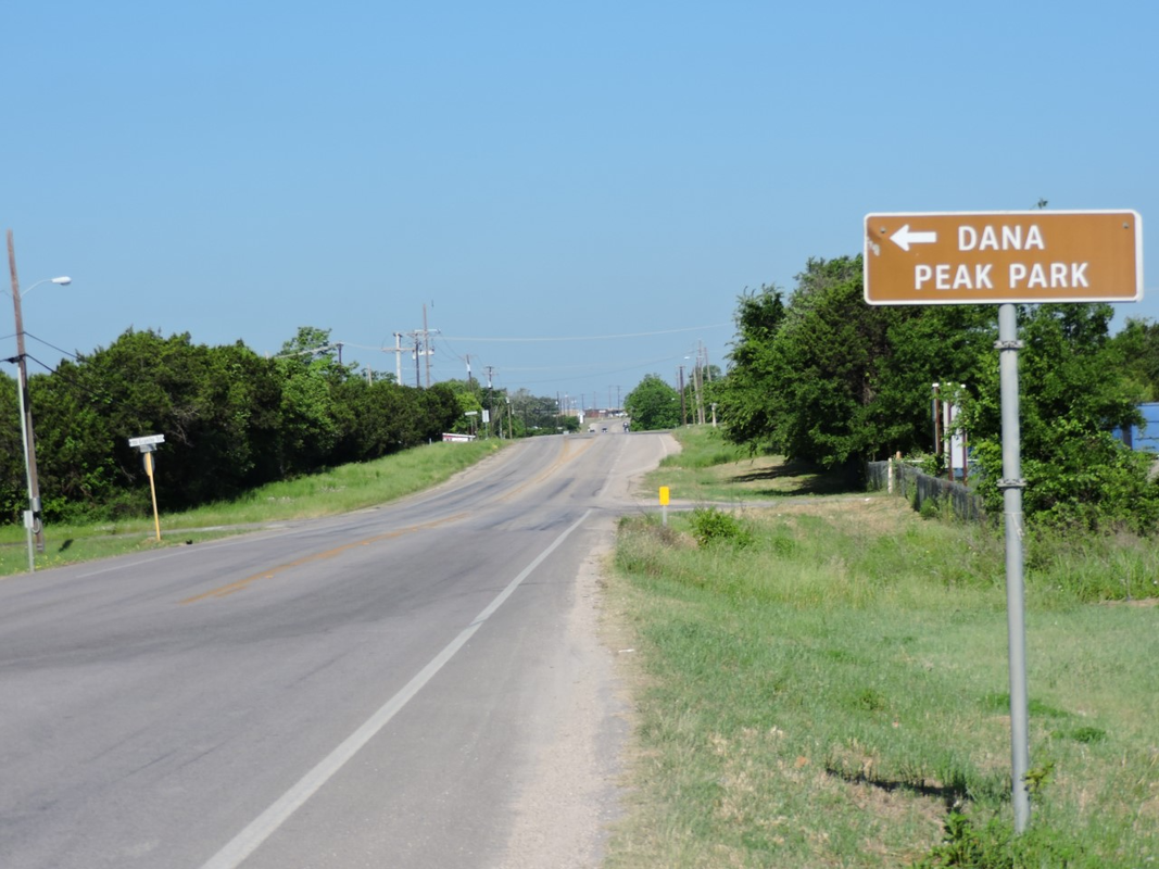 A sign on the side of a road points to dana peak park