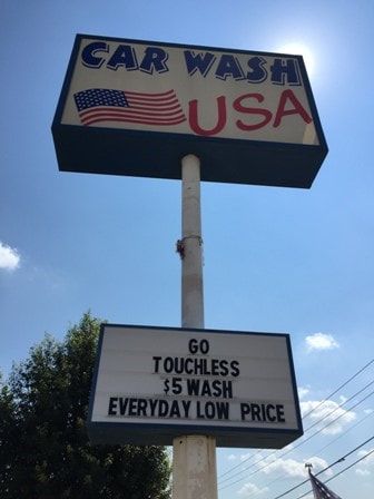 A car wash sign that says go touchless $ 5 wash everyday low price