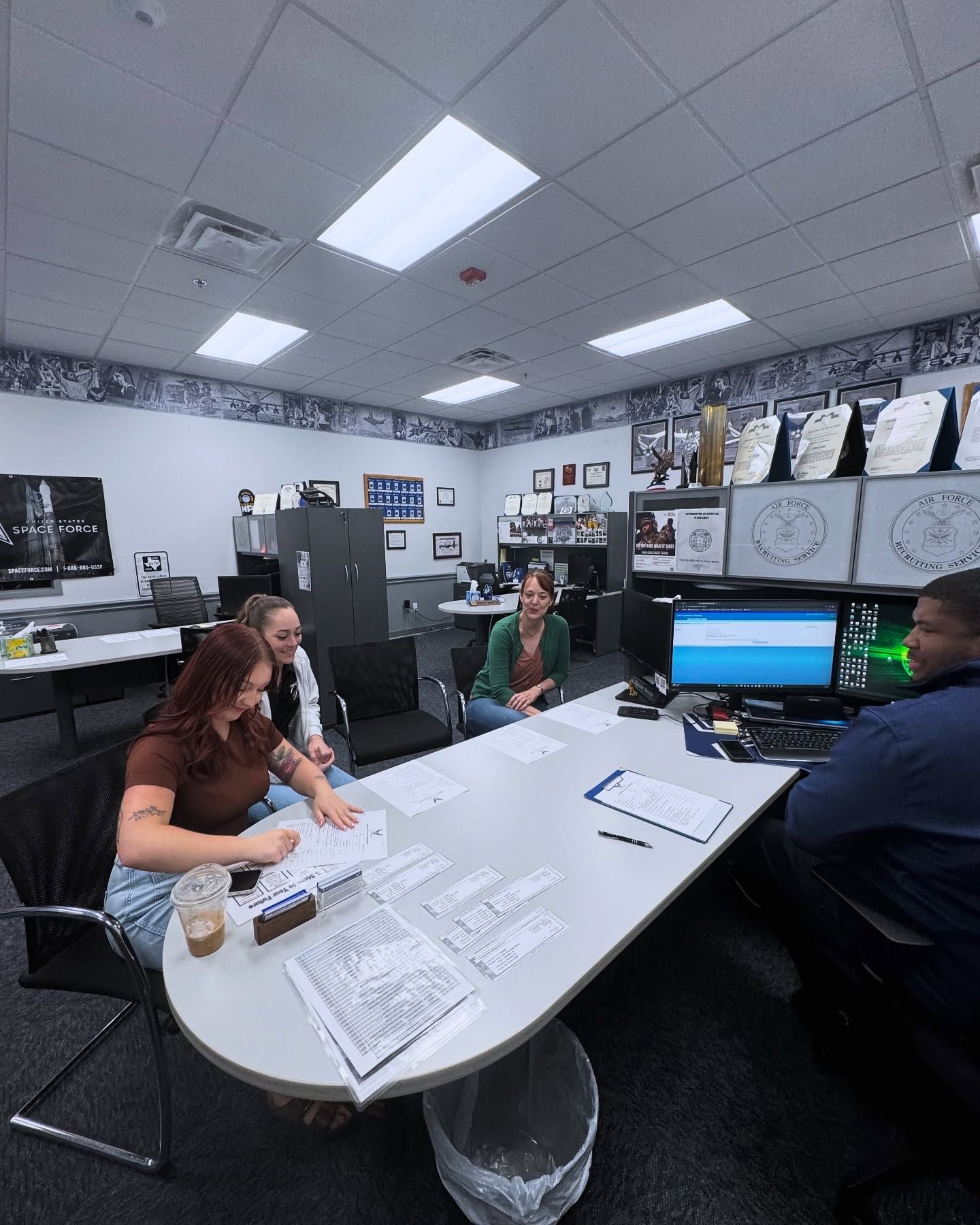 A group of people are sitting around a table in an office