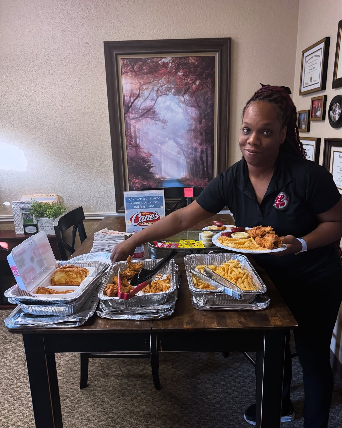 A group of people are standing in an office room talking to each other.