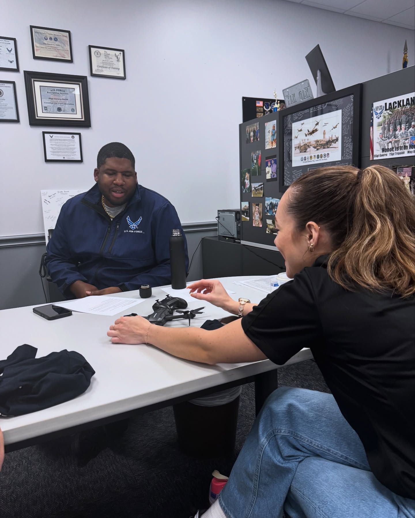 A woman is giving a massage to another woman in a dark room.