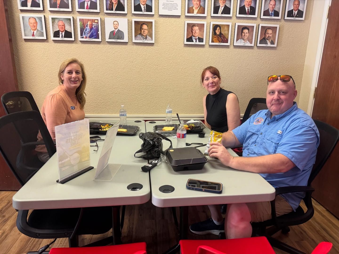A group of people are sitting at a table in a conference room.
