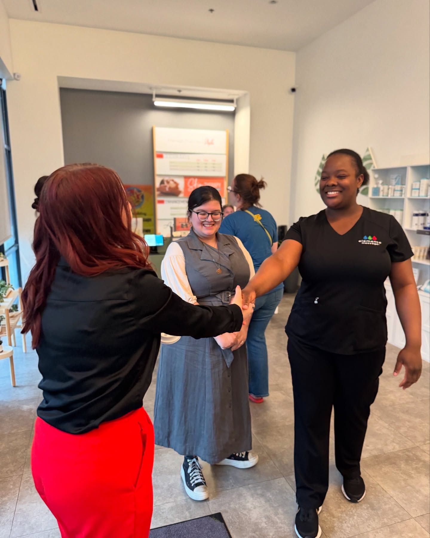 A group of women are shaking hands in a room