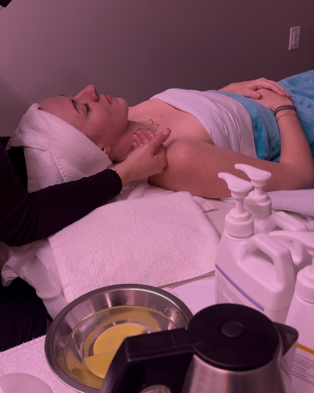 A woman is laying on a bed getting a massage