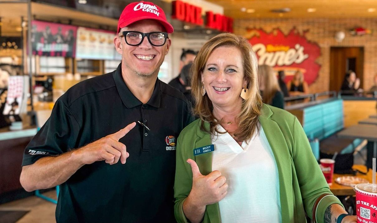 A man and a woman are posing for a picture in a restaurant.