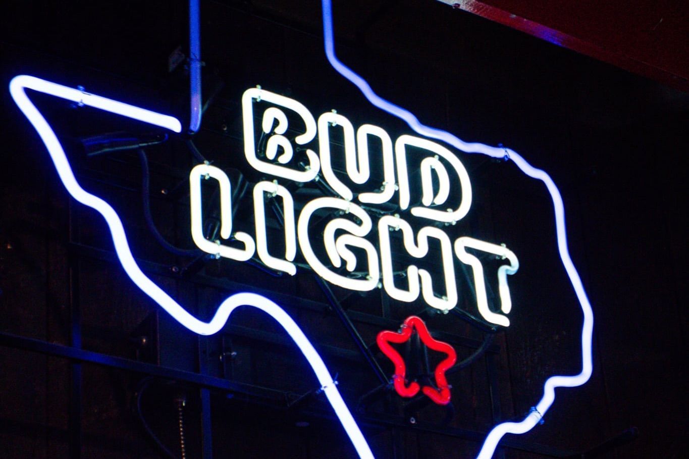A bud light neon sign with a texas map on it