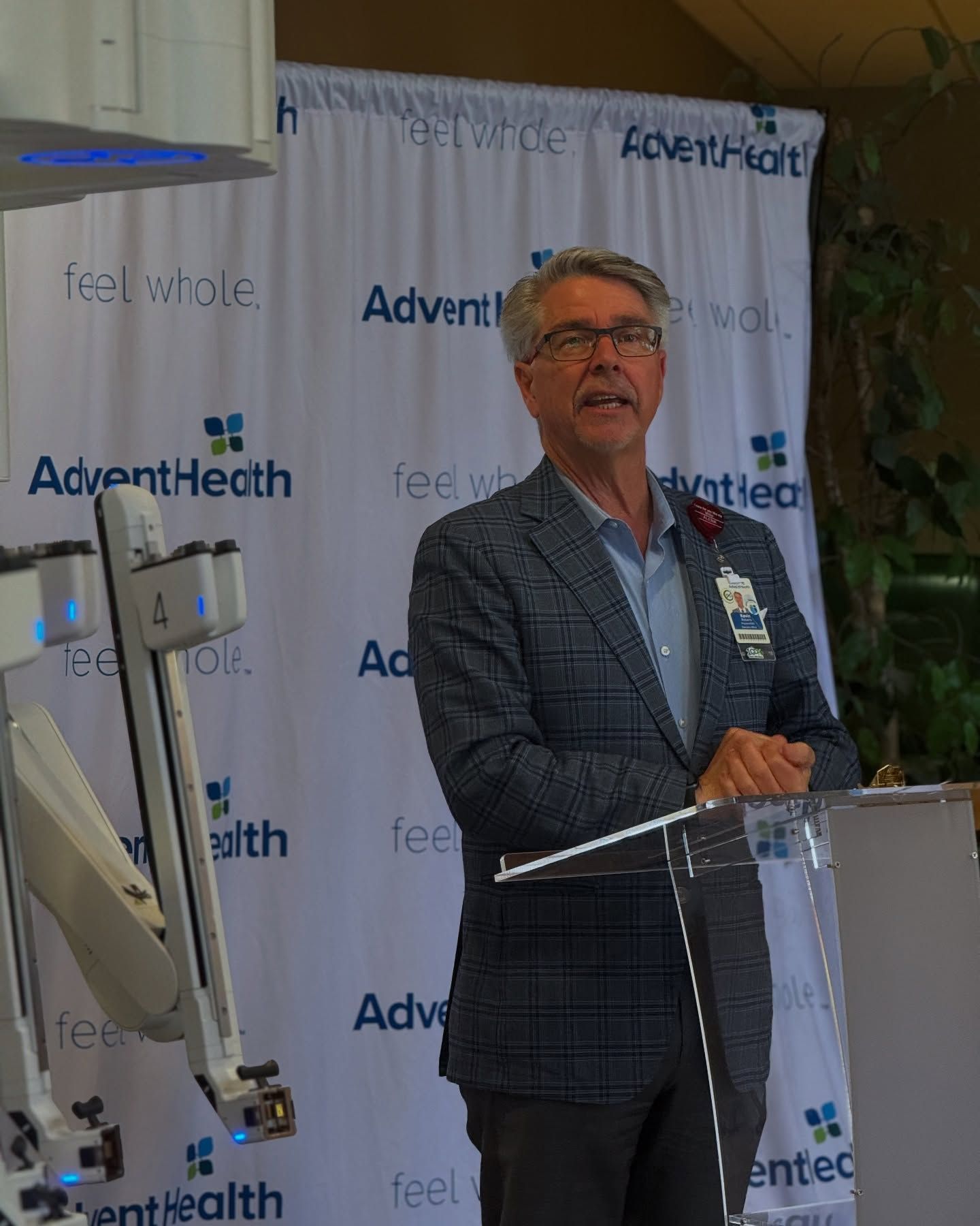 A man in a suit is standing at a podium giving a speech