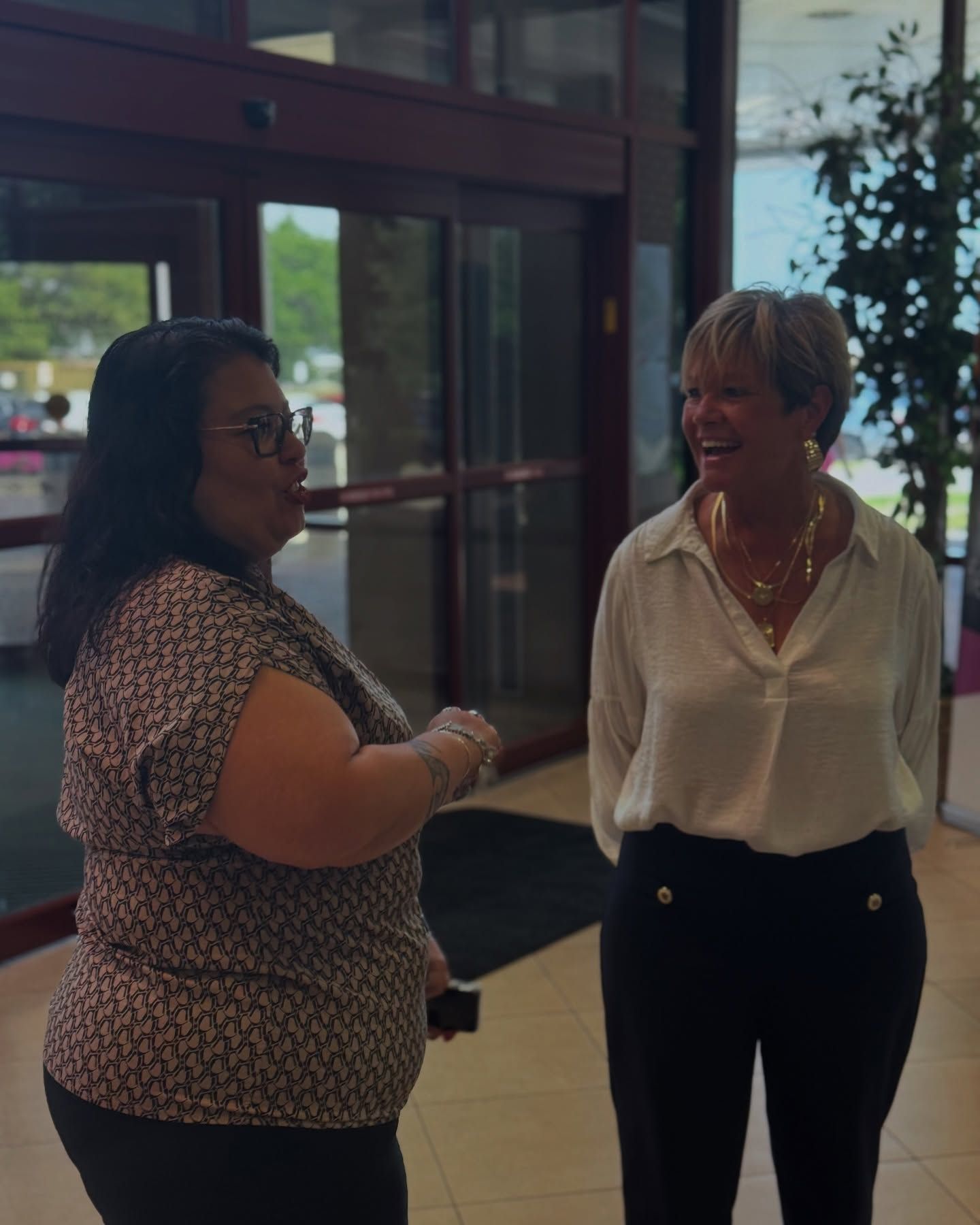 Two women are standing next to each other and talking