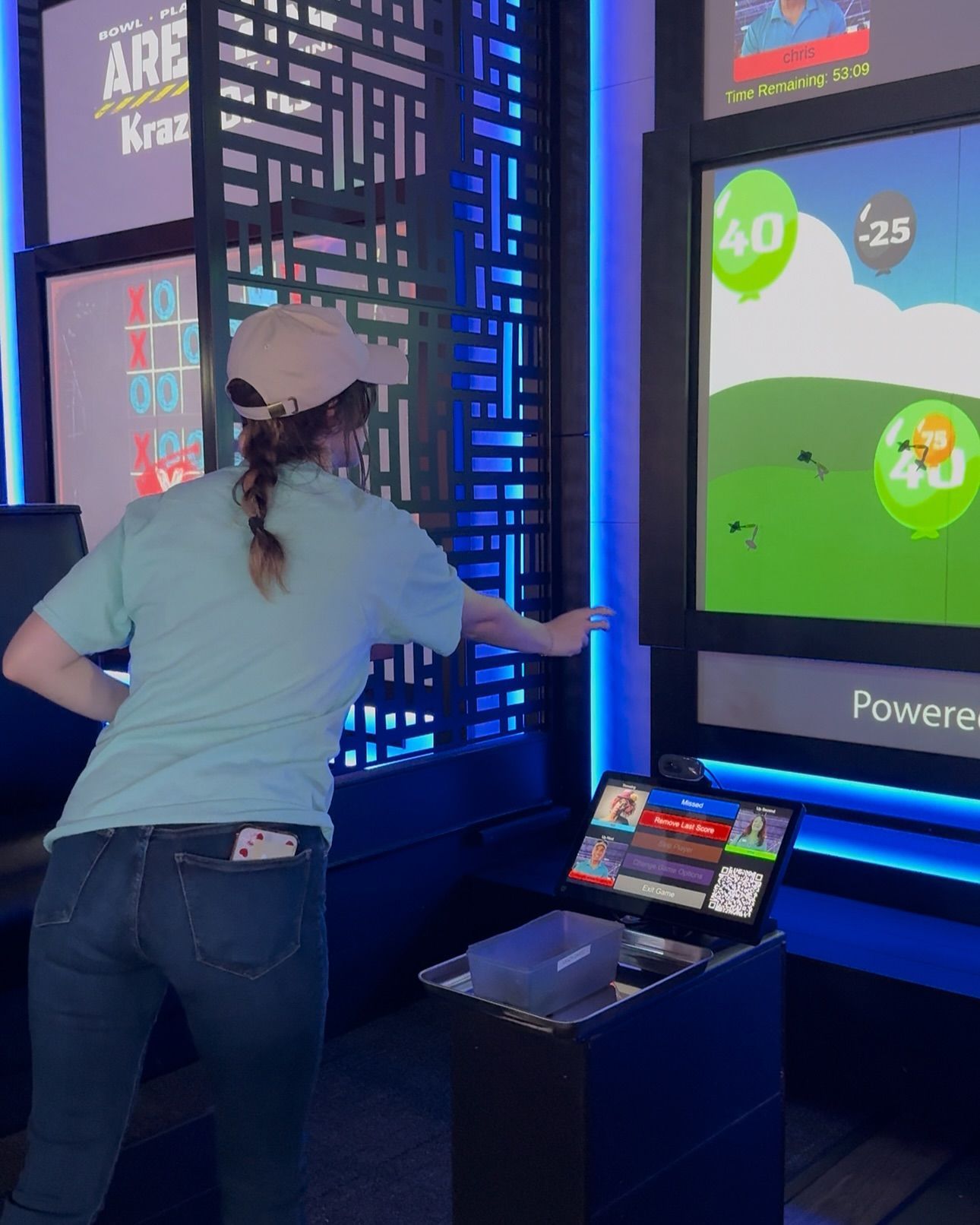 A woman is playing a digital darts game