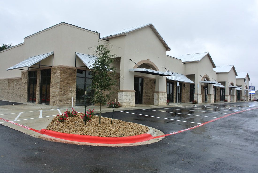 A row of buildings with a parking lot in front of them