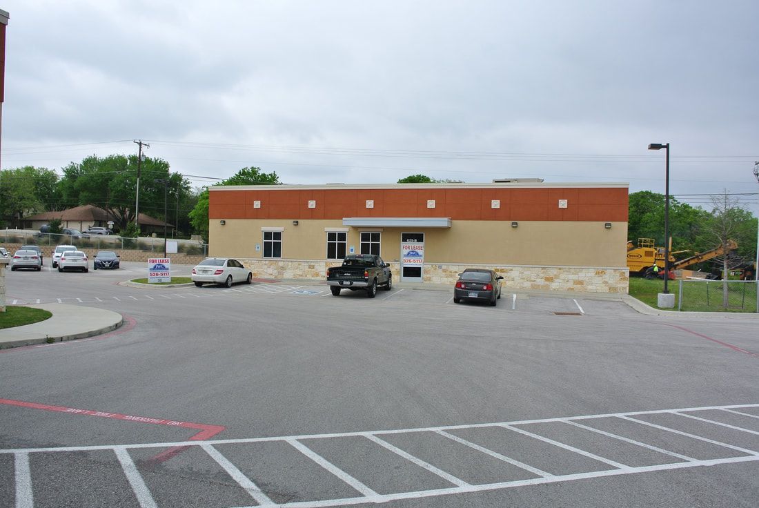 A parking lot with cars parked in front of a building