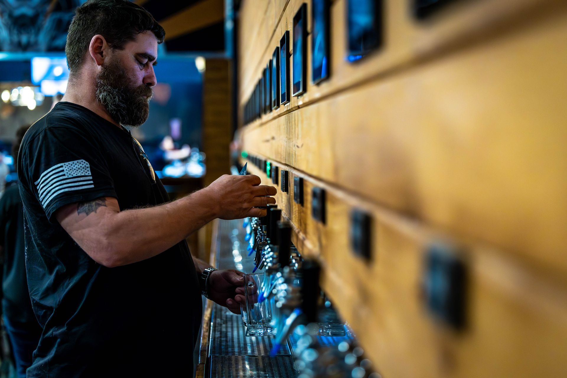 A man is pouring beer from a tap in a bar.