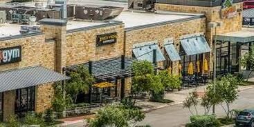 An aerial view of a shopping center with a gym and a restaurant.