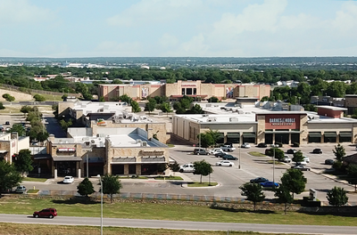 An aerial view of a city with lots of buildings and parking lots