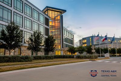 A large building with a lot of windows and trees in front of it.