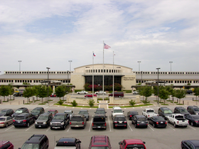 A large building with a lot of cars parked in front of it