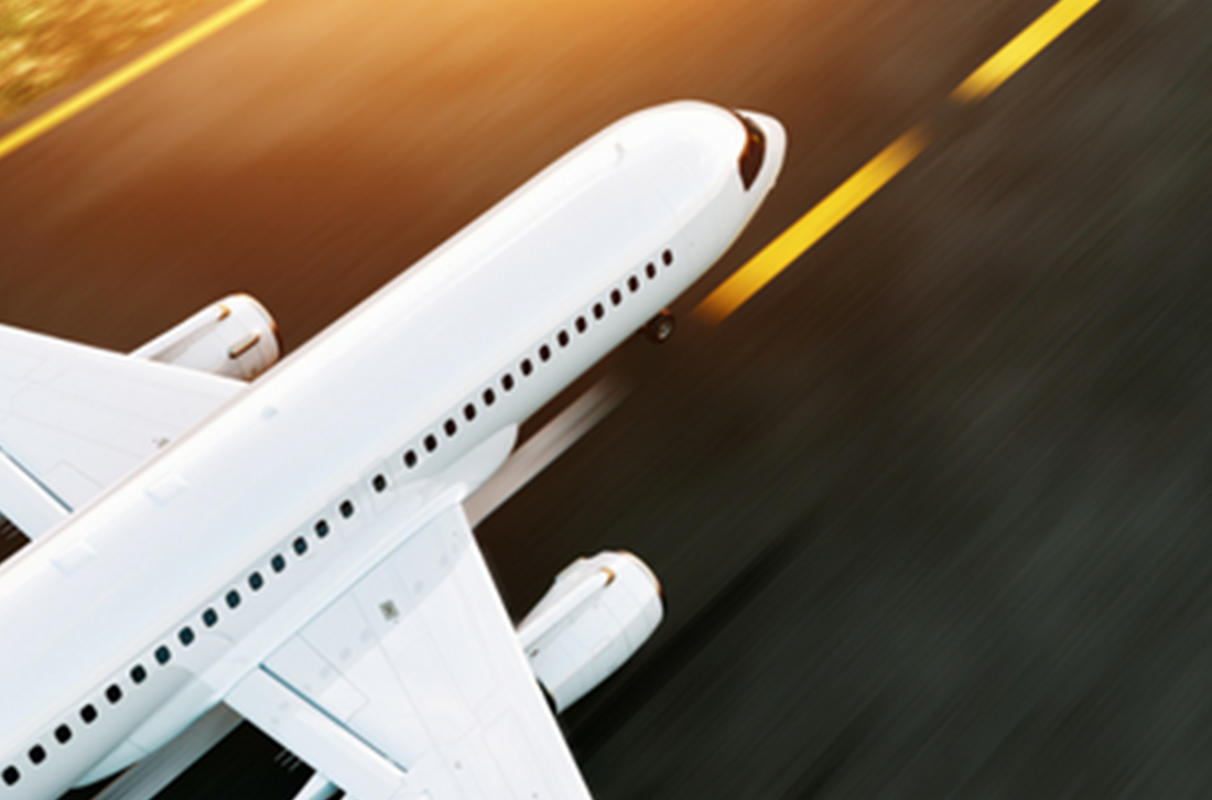 A white airplane is taking off from an airport runway