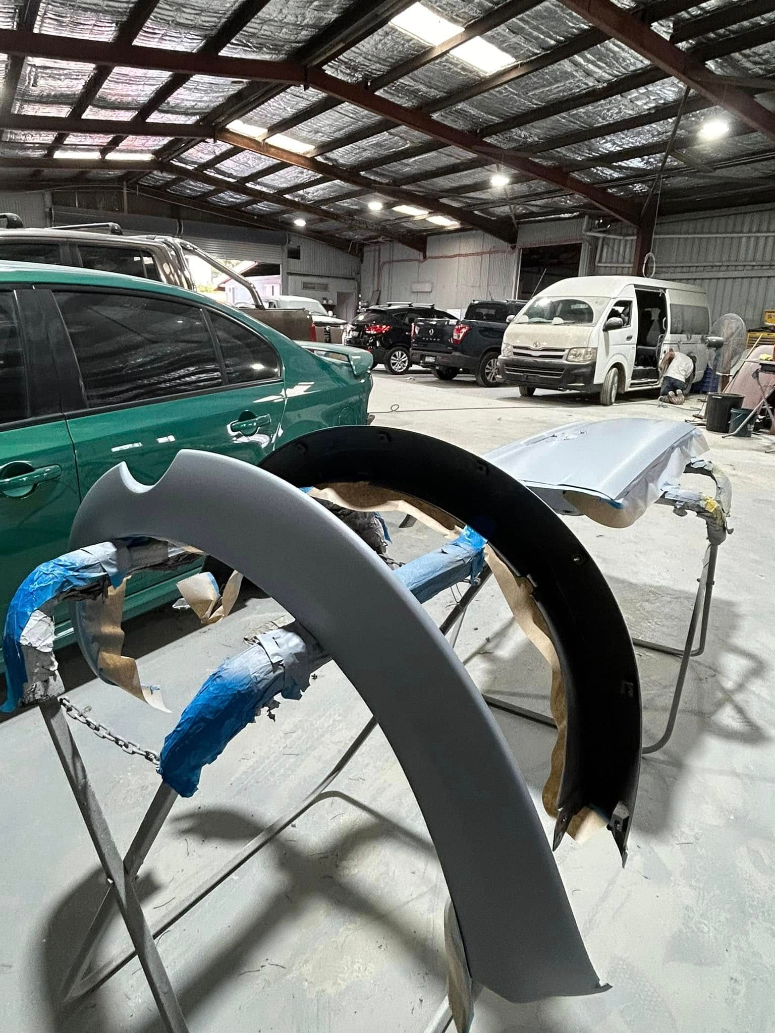A car is being painted in a garage.