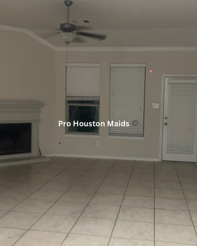 An empty living room with pro houston maids written on the bottom