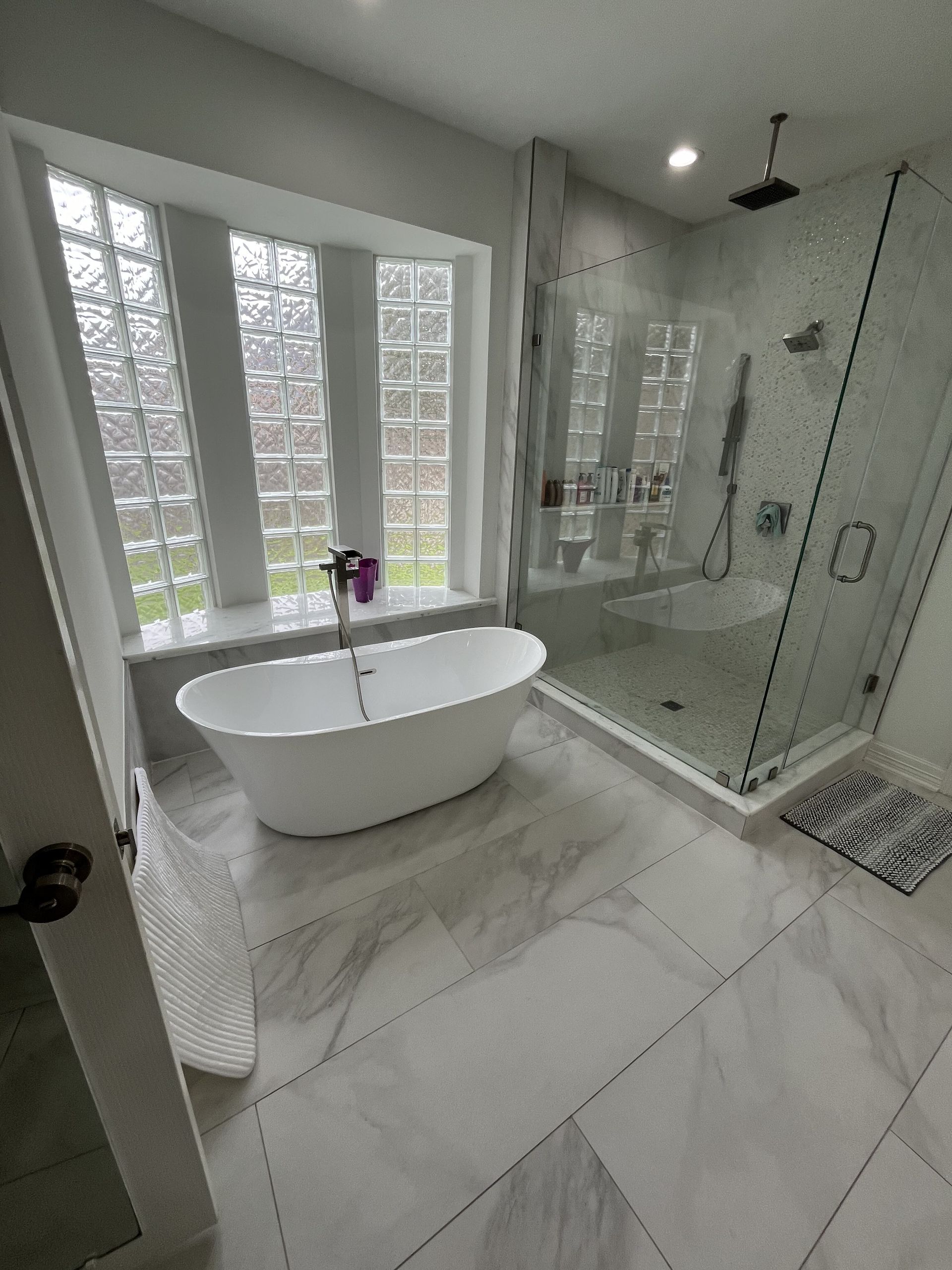 A bathroom with a bathtub and a walk in shower.
