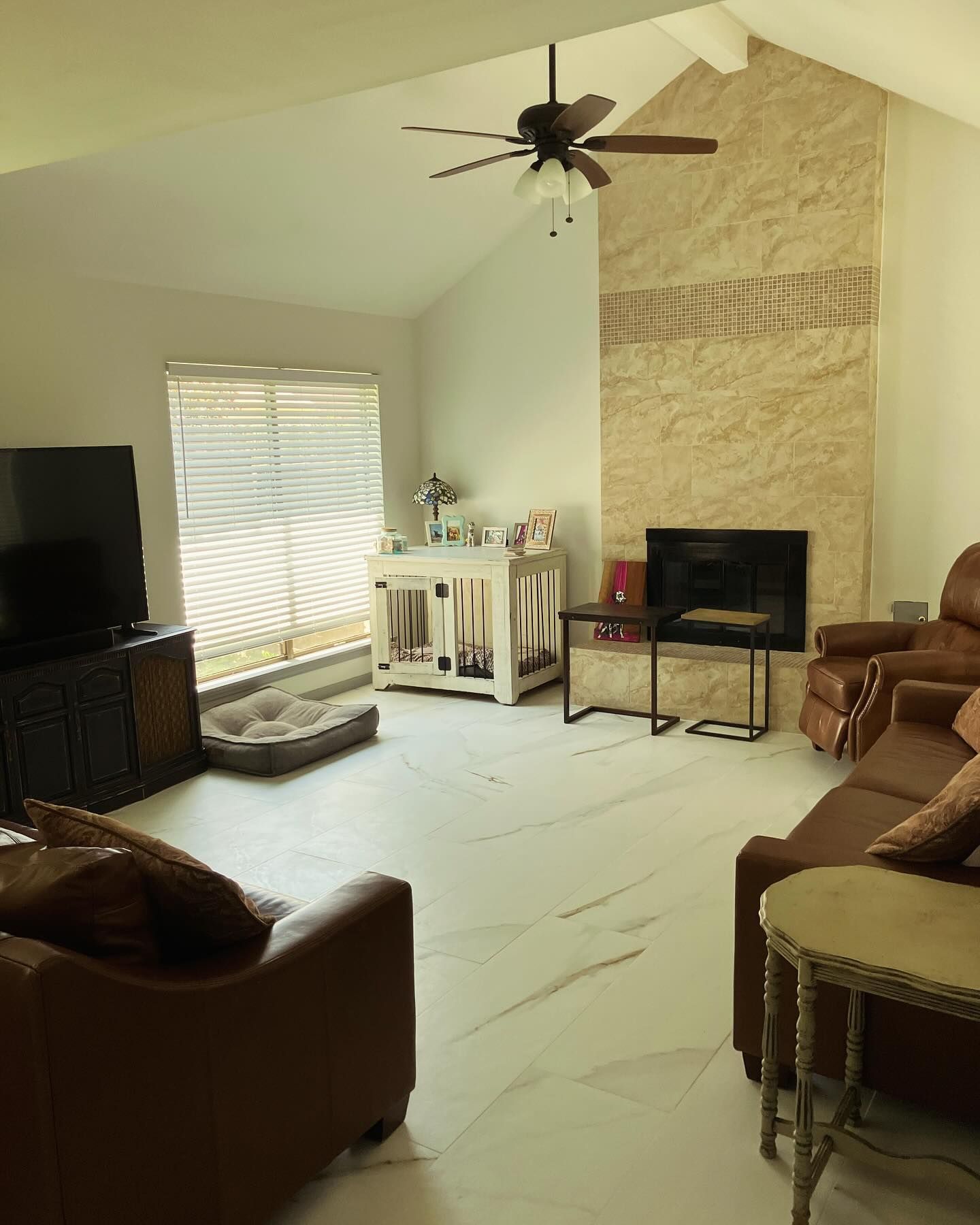 A living room with a ceiling fan and a fireplace