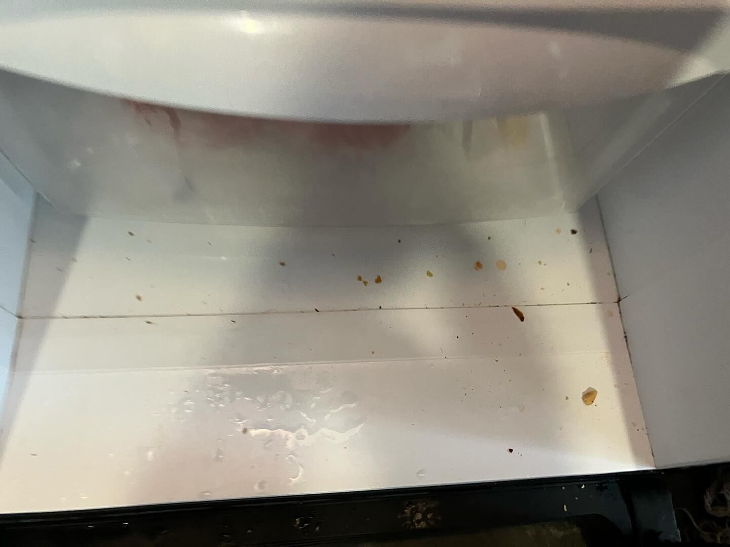 The inside of a refrigerator with a lot of stains on it.
