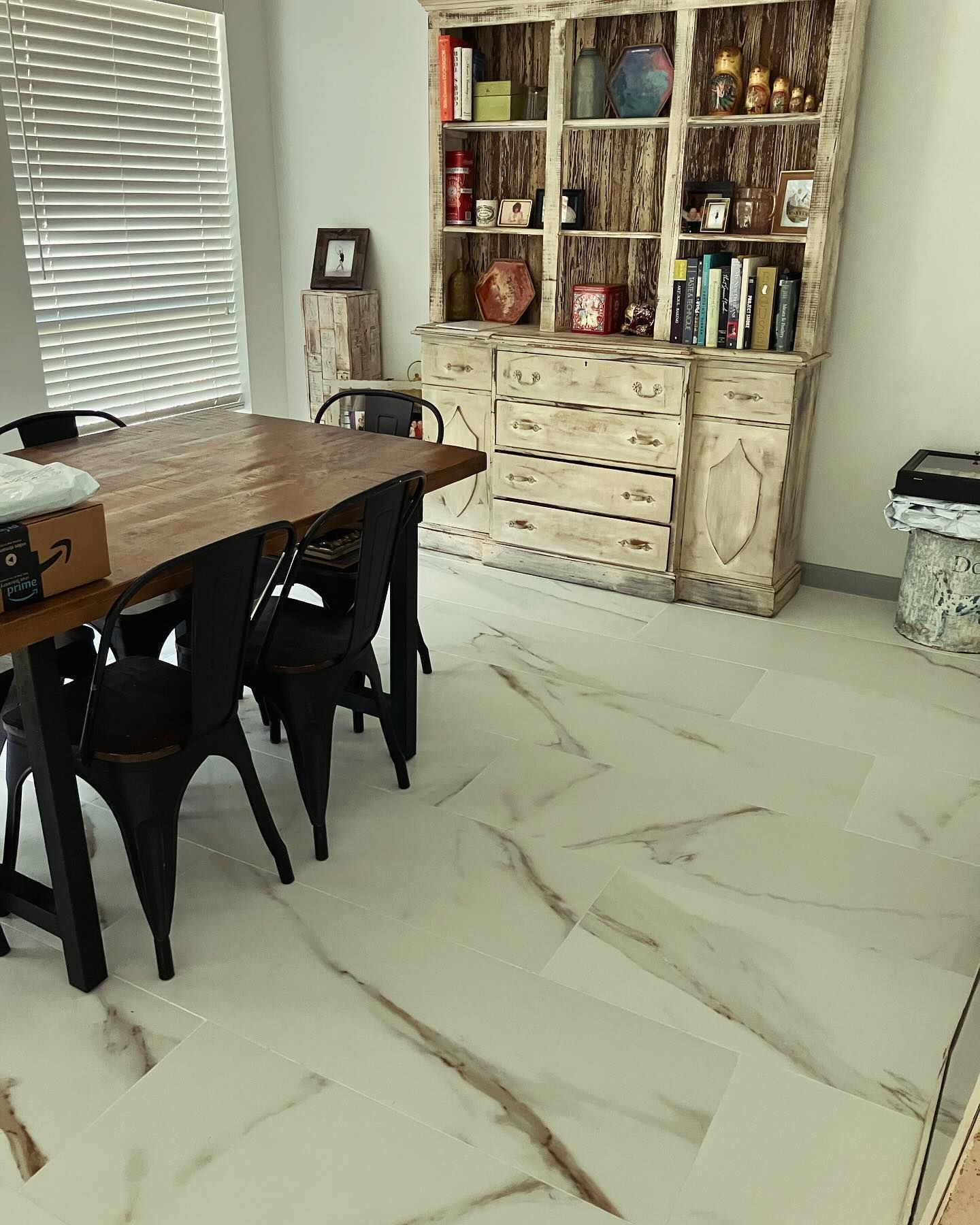 A dining room with a wooden table and chairs and a hutch.