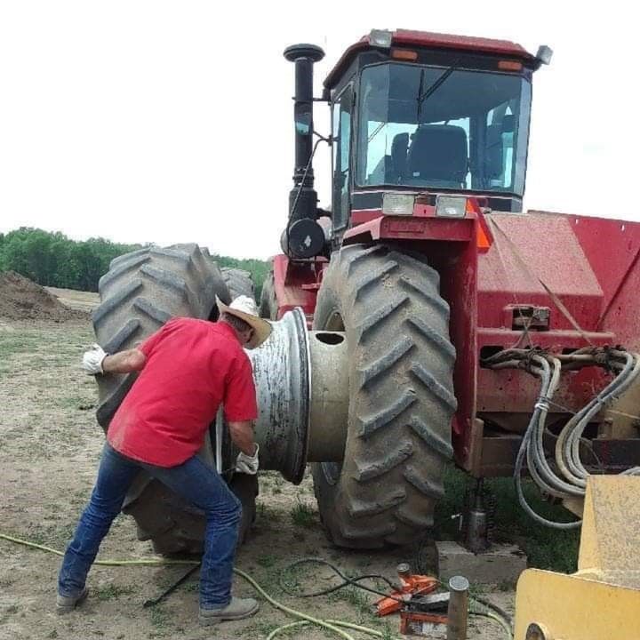 White car being loaded onto a tow truck on the side of a road.