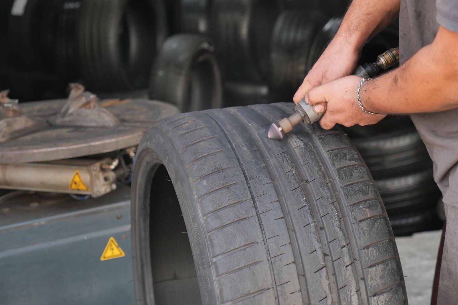 Yellow tow truck carrying a black car on a sunny street.