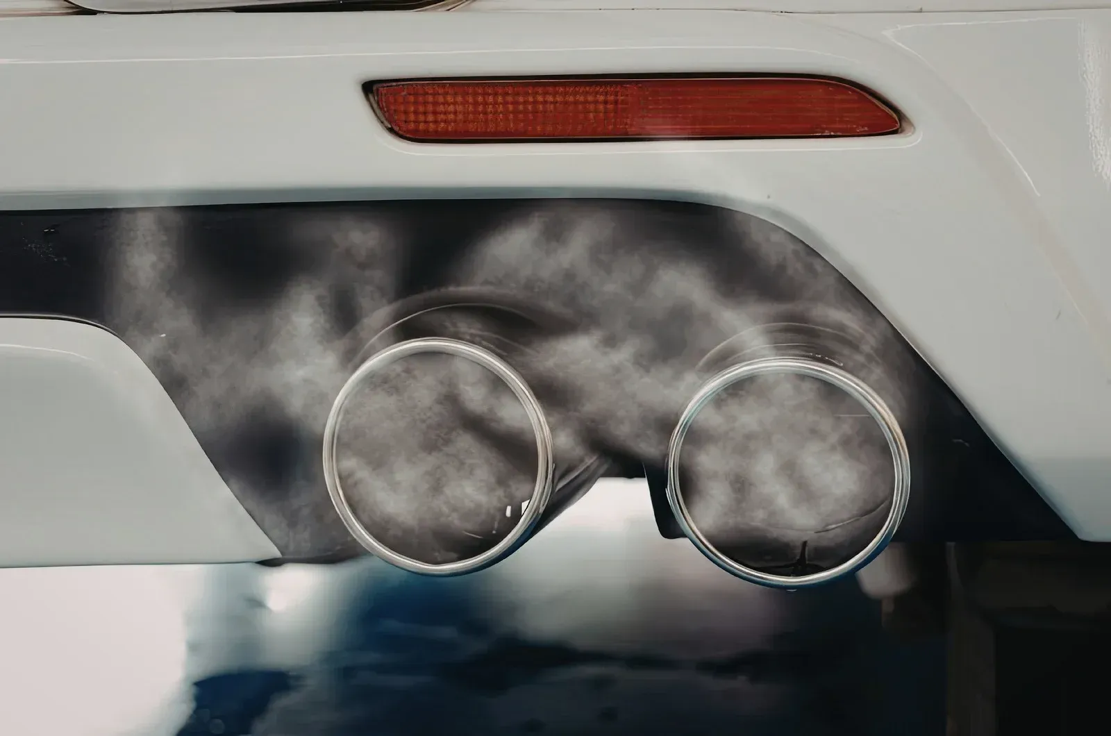 Tow truck carrying a silver station wagon on a highway.