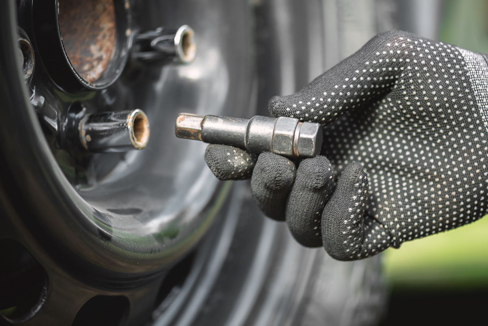Tow truck carrying a silver station wagon on a highway.