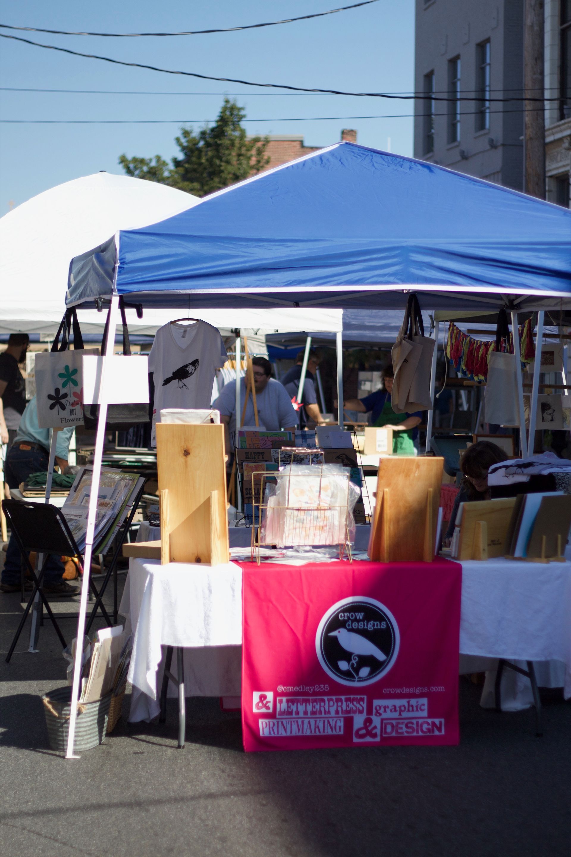 A pink flag with a bird on it is sitting under a blue tent