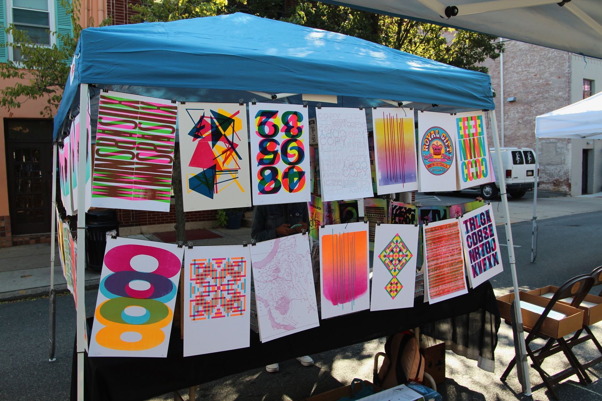 A blue tent with a bunch of colorful posters on it