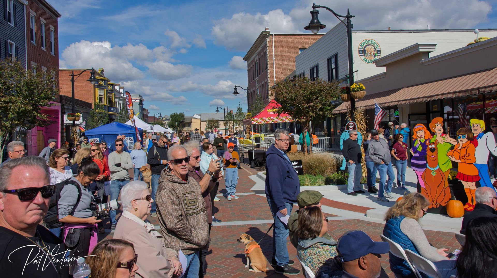 A brick walkway leading to a large mural on the side of a building.