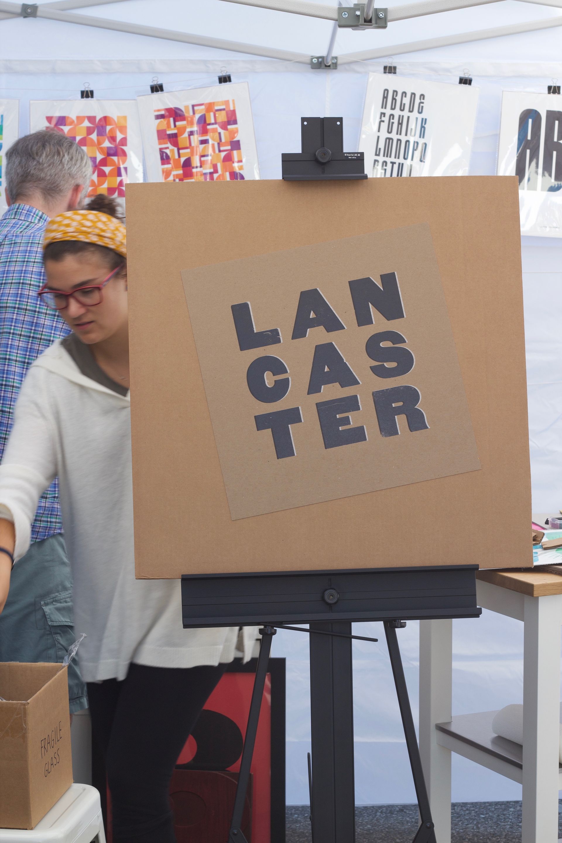 A woman stands in front of a sign that says lan caster