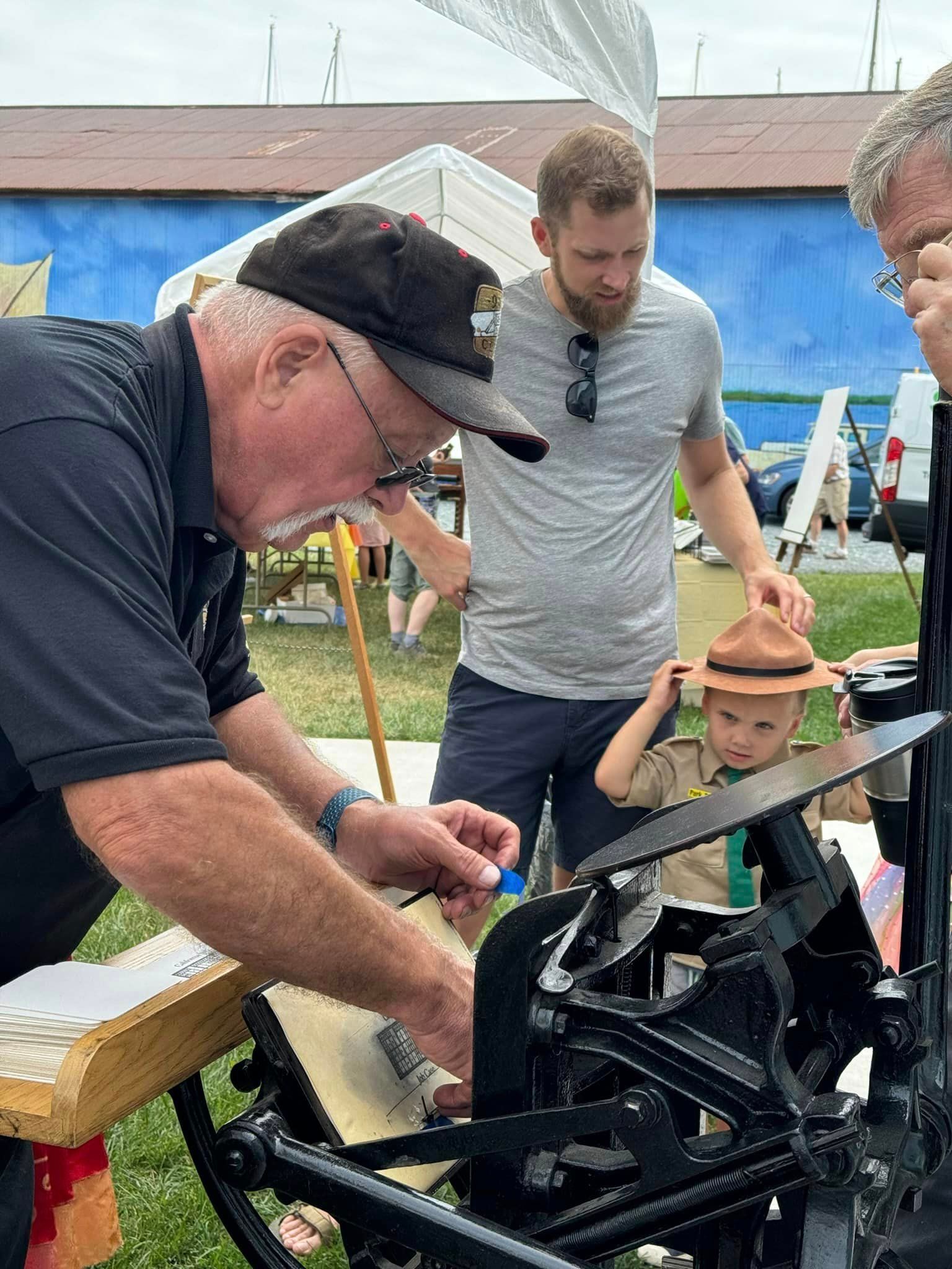 A man is working on a machine while a boy looks on.