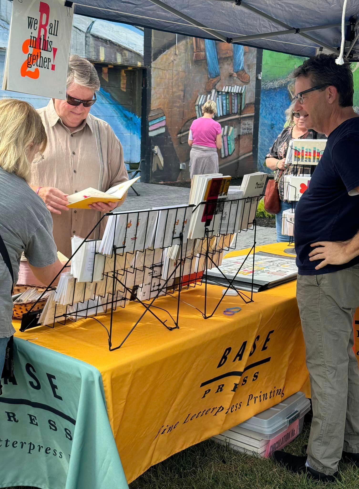 A group of people are standing around a table at a market.