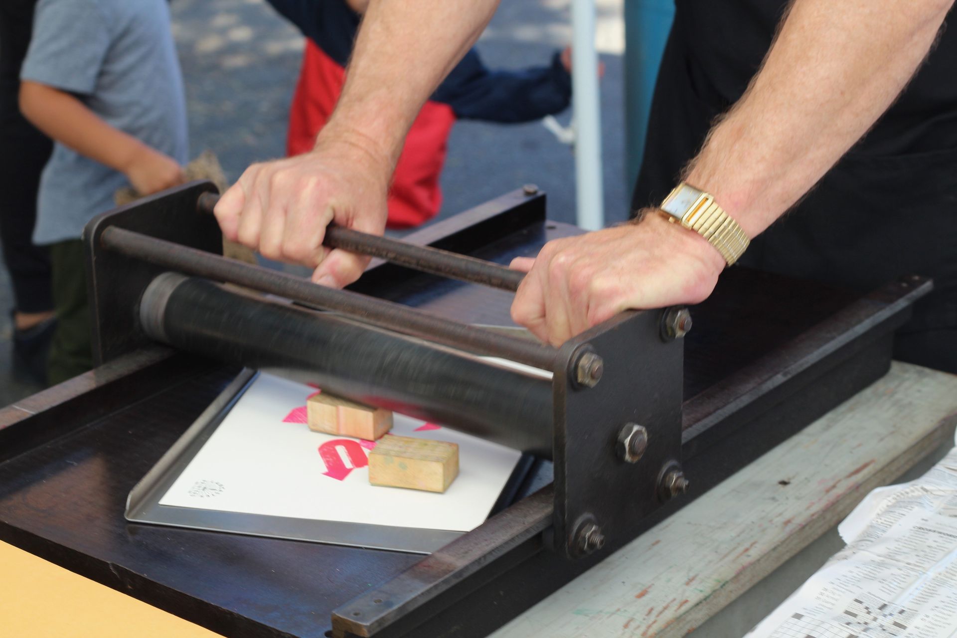 A man is using a machine to cut a piece of paper