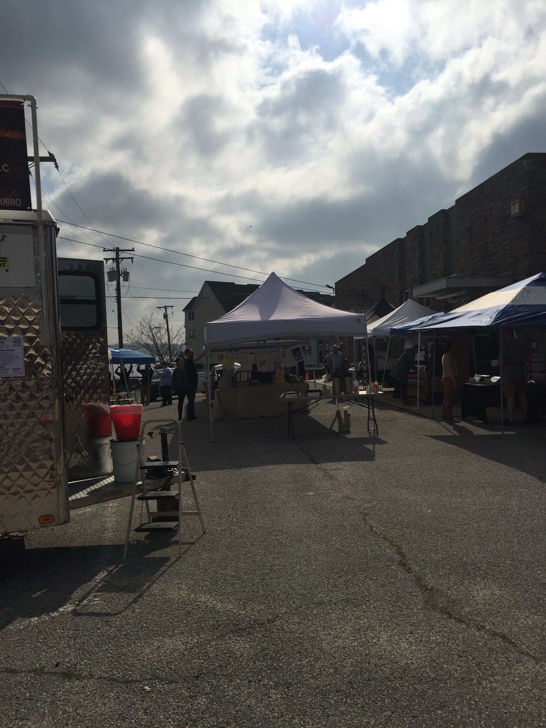 A lot of tents are lined up in a parking lot