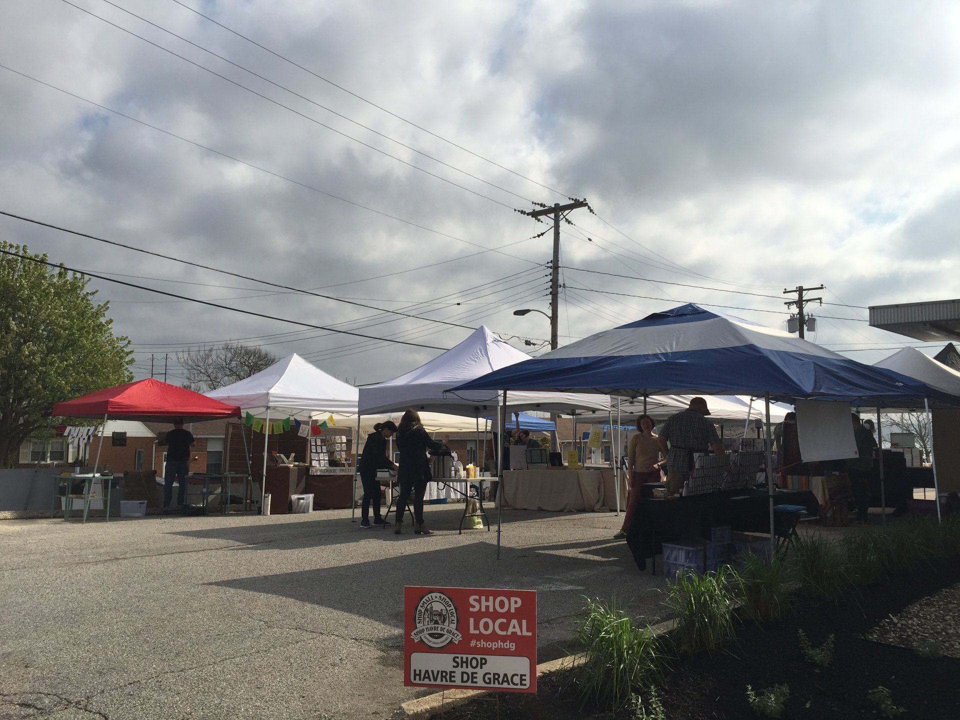 A sign that says shop local is in front of a market