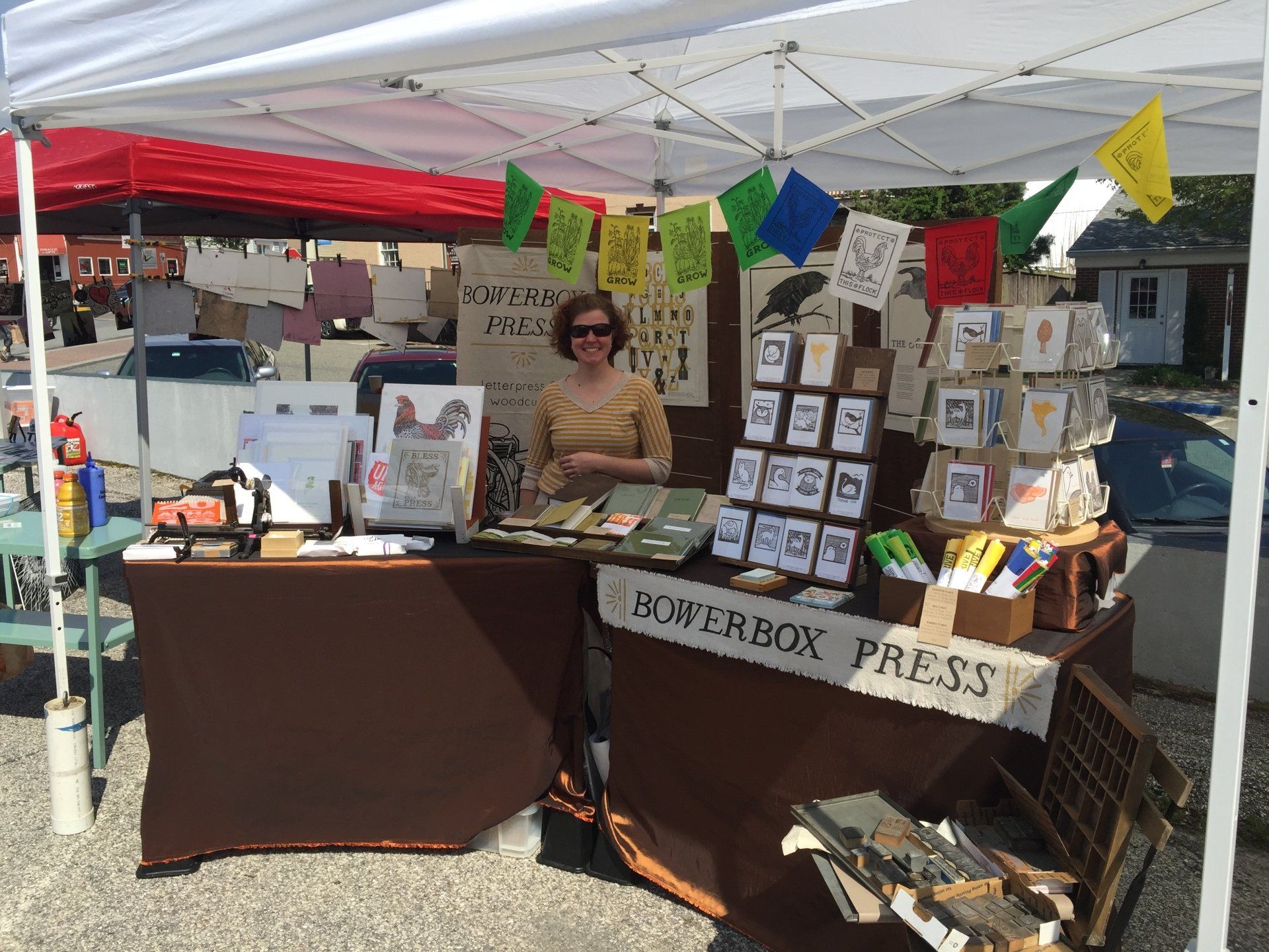 A woman is standing behind a table that says ropebox press