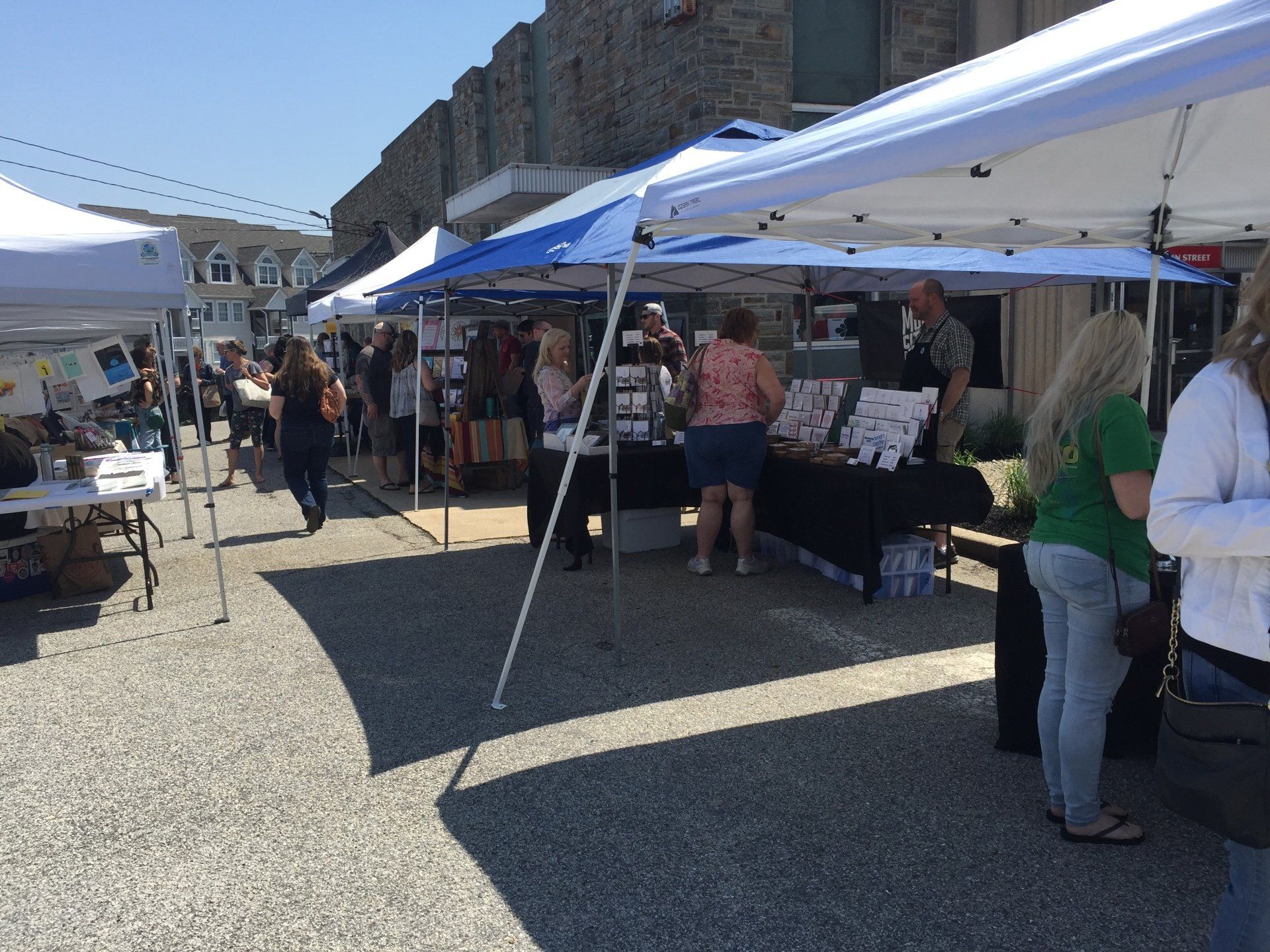 A group of people are standing under tents at a market