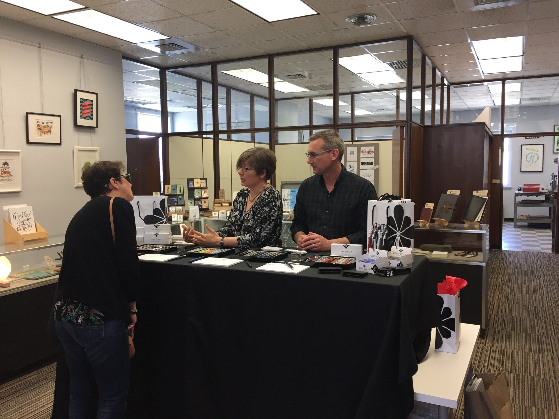 A group of people are standing around a table in a room.