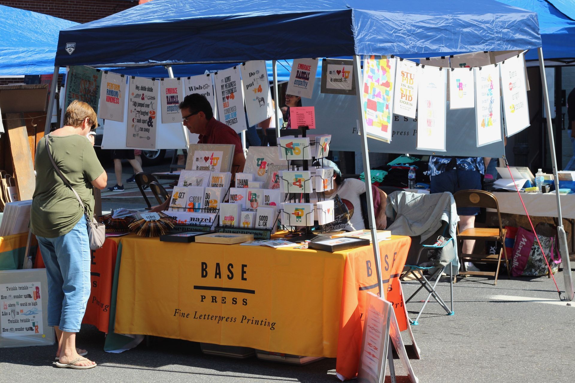 A woman is standing in front of a table that says base books